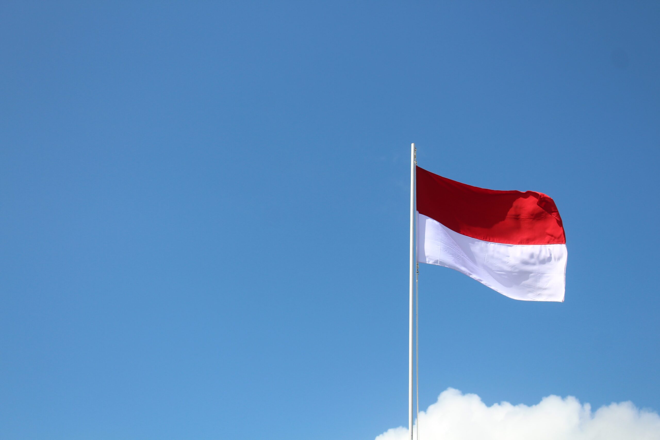 Indonesian flag blowing in clear skies