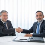 Business partners shaking hands after signing legal documents for apostille and embassy legalization services.