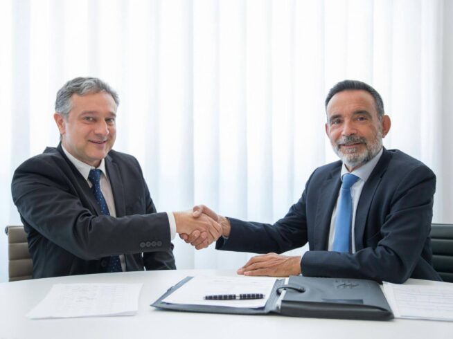 Business partners shaking hands after signing legal documents for apostille and embassy legalization services.